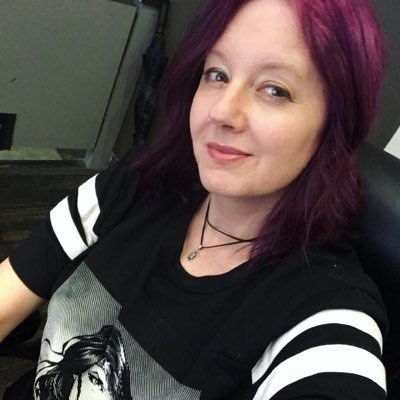 Headshot of Marti with purple hair and Wonder Woman Shirt